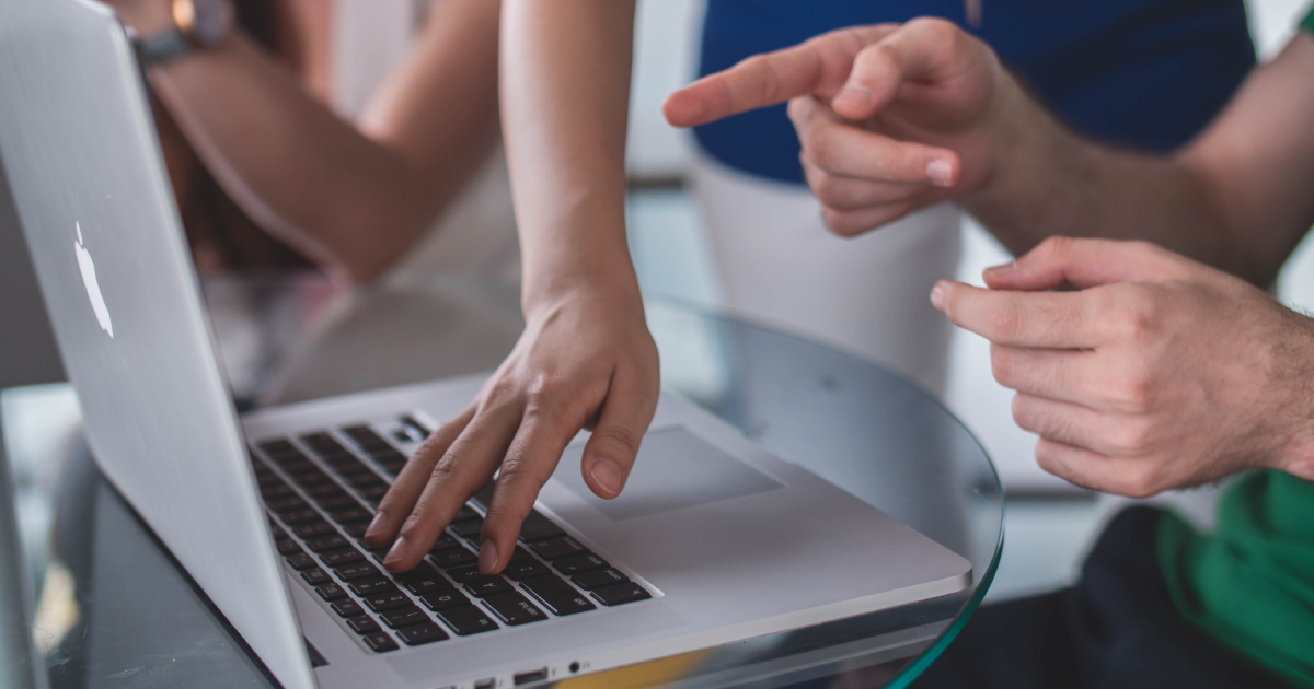 Hands gesture at and touch a laptop keyboard