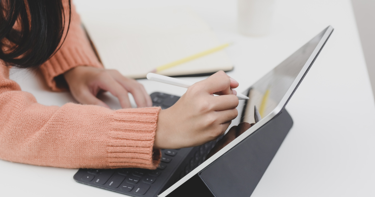 Hand uses electronic pen to write on tablet