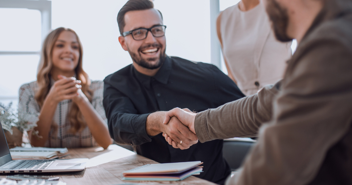 People shake hands during deal for company buy-in