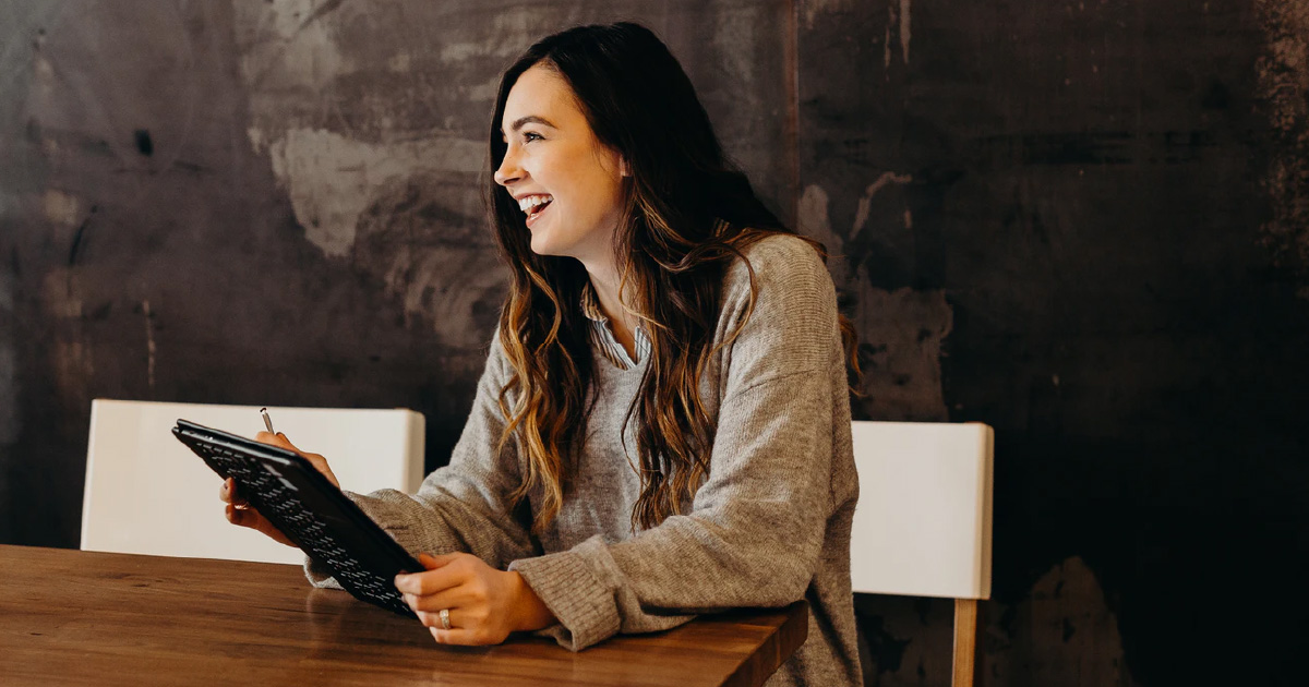 Enablement leader smiles while holding tablet