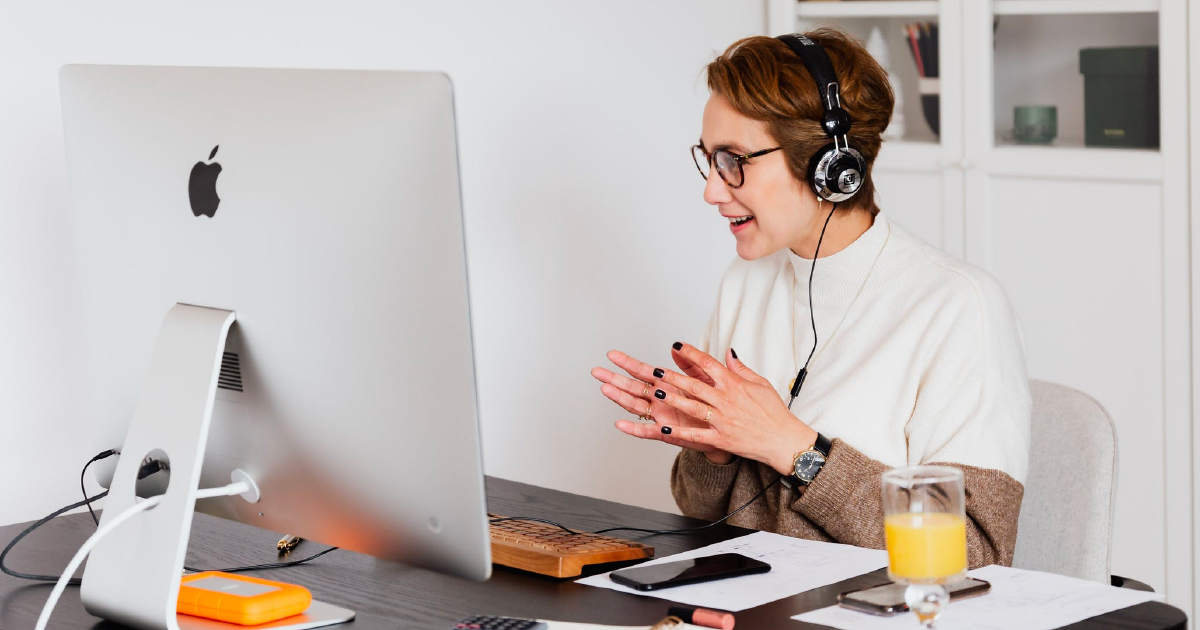 Person sitting in front of computer sits in front of Apple desktop