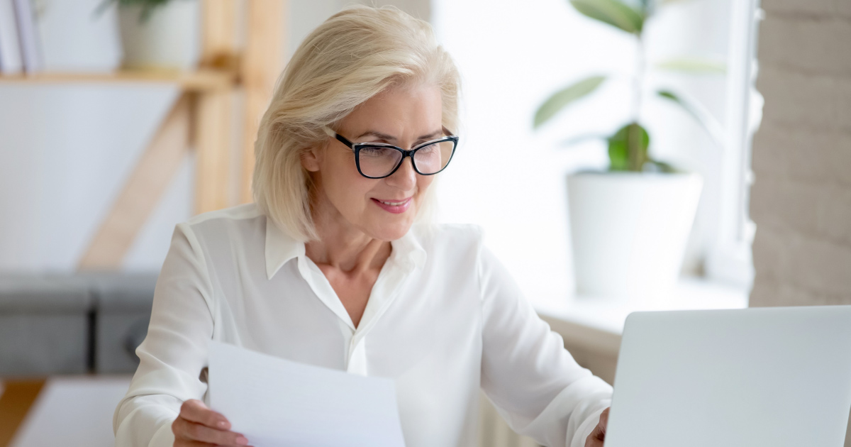 Person looking at papers and a computer