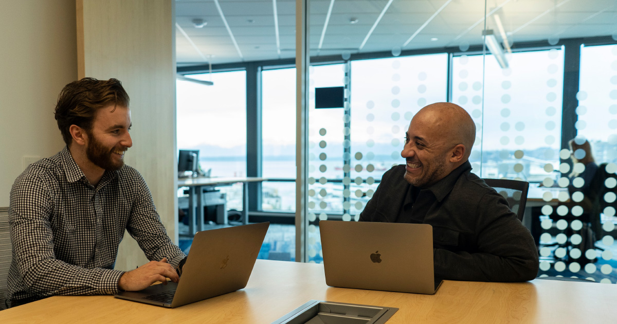 Two people at a desk talk about what makes a workplace great in 2021