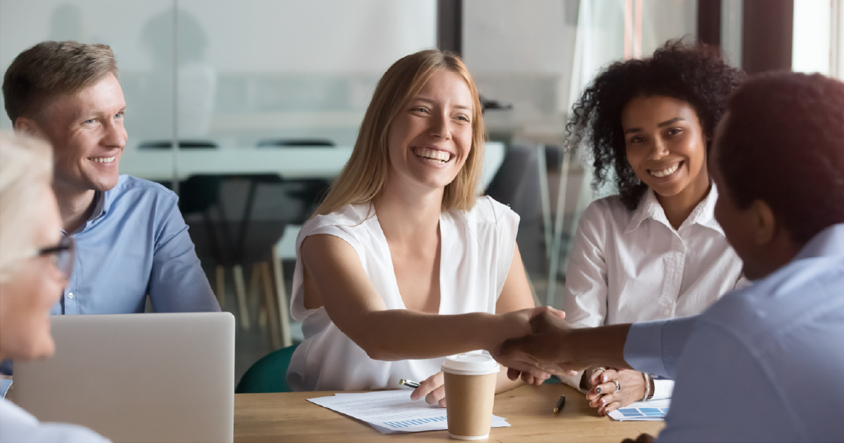 Two smiling people shake hands