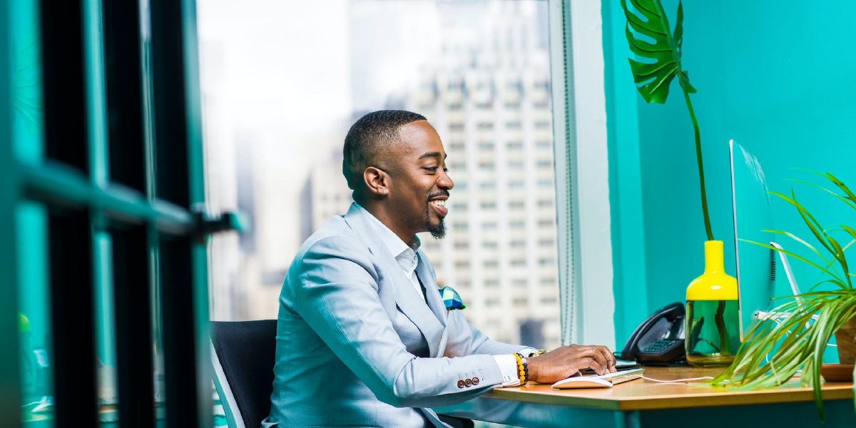 Person smiles at computer screen in office