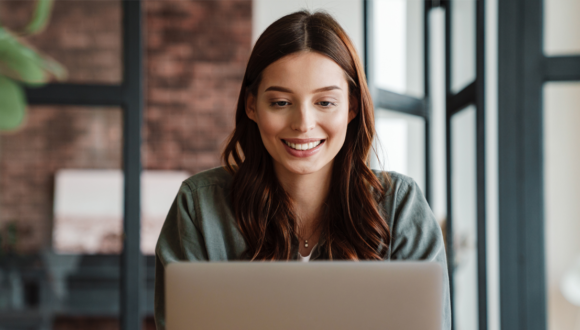 Person smiles at laptop