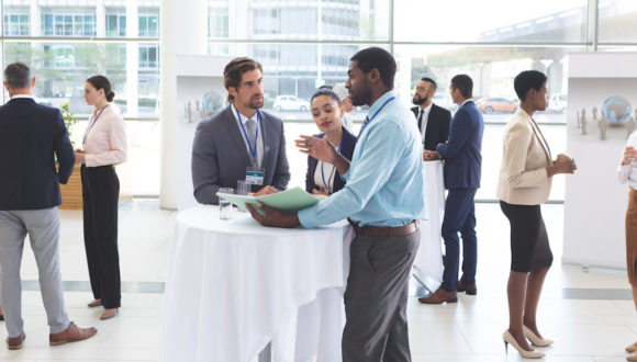 Business people discussing over documents at table during a seminar