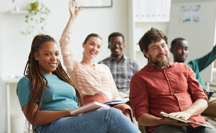 Five people smile in a meeting