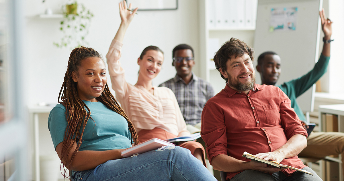 Five people smile in a meeting