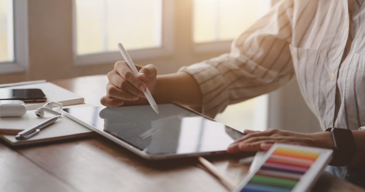 Hand uses electronic pen to write on tablet