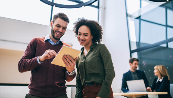 Two people smiling at a sales enablement maturity report in 2021