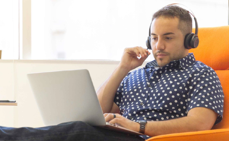 Person wearing headset looking at computer