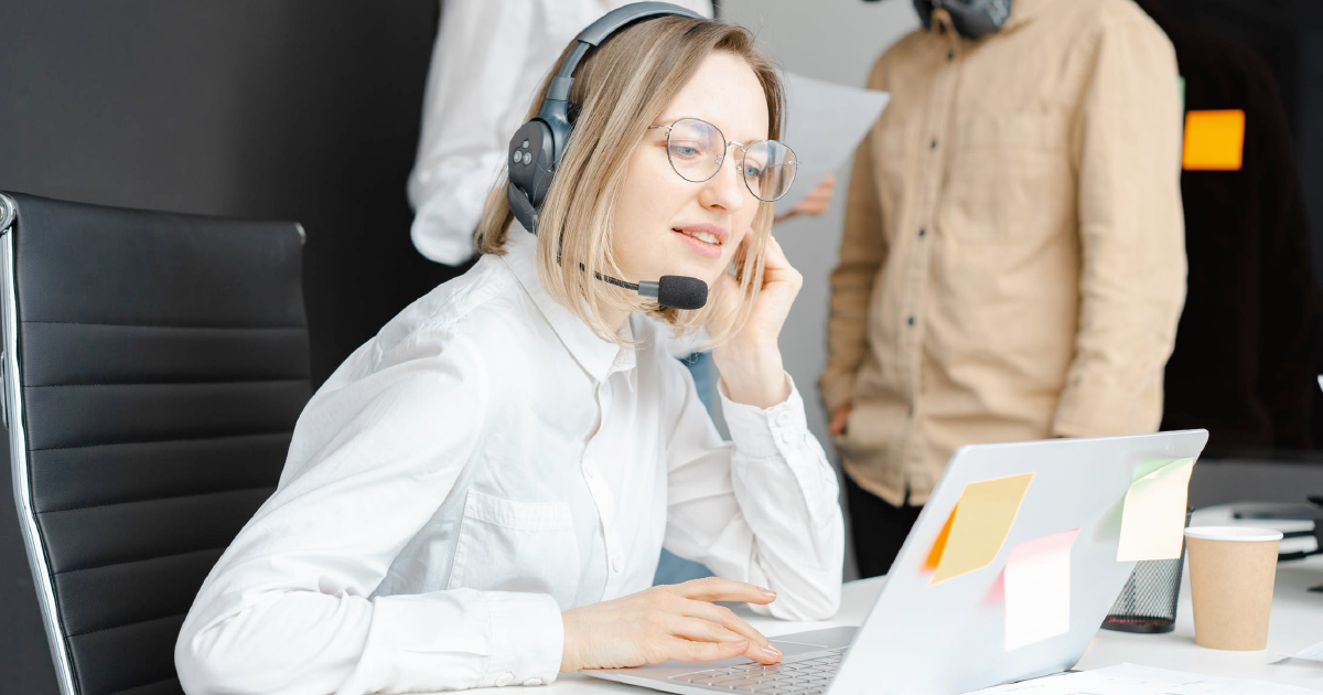 Salesperson takes a call while looking at computer